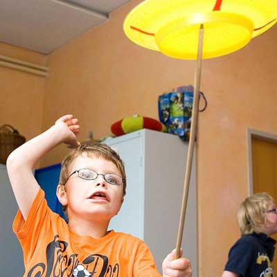 Junge ballanciert Teller auf Stab