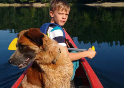 Junge und Hund in Kanu