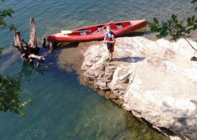 Junge vor Kanu am See