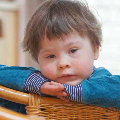 Kindergartenkind blickt über Stuhl