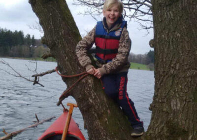 Schüler bindet Kanuan Baum fest