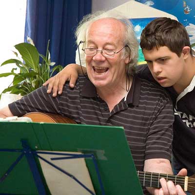 Schüler und Lehrer spielen Guitarre