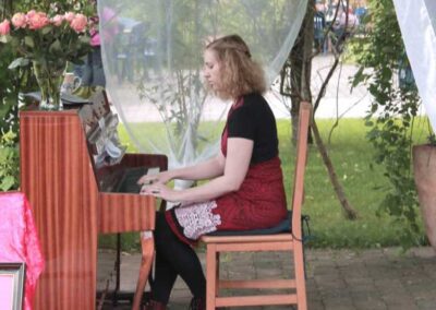 Frau spielt Klavier im Garten