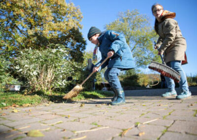 Kinder fegen den Hof