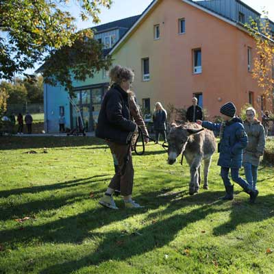 Kinder mit Esel im Garten