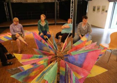 Gruppe im Saal im Kreis sitzend