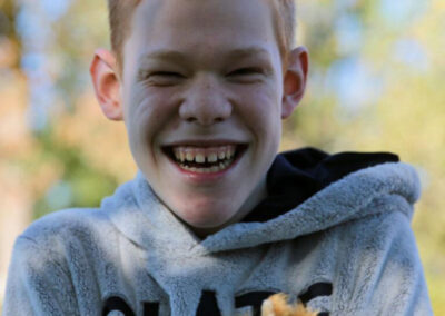 Lachender Junge mit Kastanien in der Hand