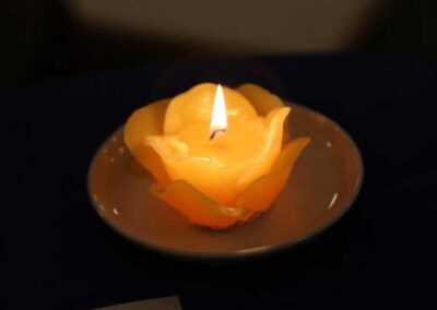 brennende Kerze in Form einer Rose