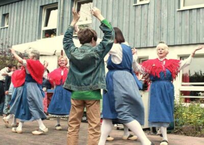 Trachtentänzerinnen vor Haus